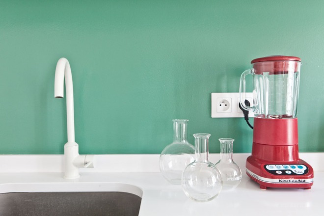 Frontal de la cocina en verde que contrasta con la batidora roja.