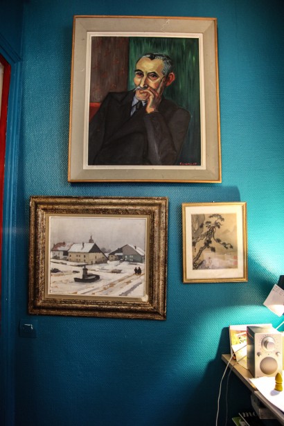 La pared azul hace resaltar los cuadros y dibujos.