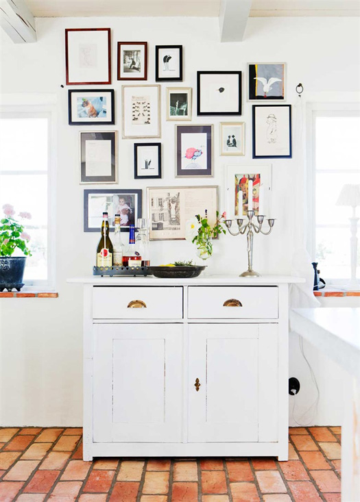 Precioso detalle de decoración con cuadros en la cocina. Componen muy bien un espacio de almacenaje dentro de la cocina comedor.