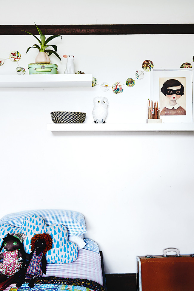 Me encanta la lámina de la chica del antifaz y los demás elementos decorativos de esta habitación infantil.