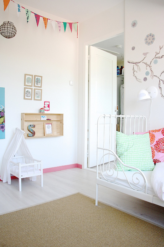Preciosa habitación infantil de una niña con la cama de hierro forjado.