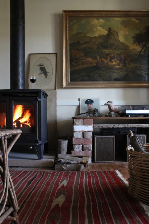 Estufa de hierro colado preciosa con ladrillos refractarios, un kilim a rayas, cuadro clásico... La mezcla de los elementos queda muy bien, veis que son muy diferentes entre sí.