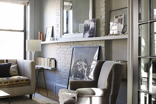 Rincón del estar con un estante  y fotos por todas partes.